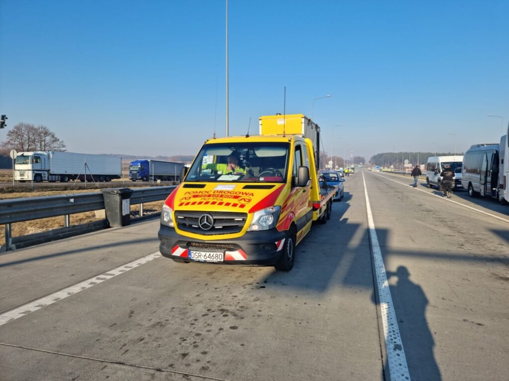 Profesjonalna laweta Legnica w trakcie transportu unieruchomionego samochodu na bezpieczne miejsce po awarii na drodze