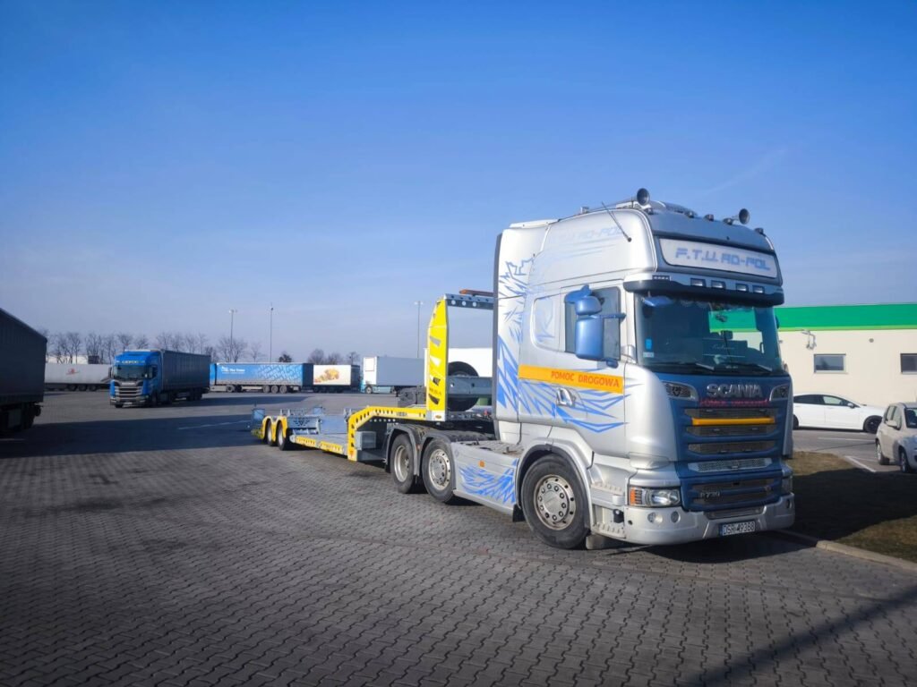 Laweta Legnica podczas załadunku uszkodzonego auta na drodze, szybka pomoc w awaryjnych sytuacjach.