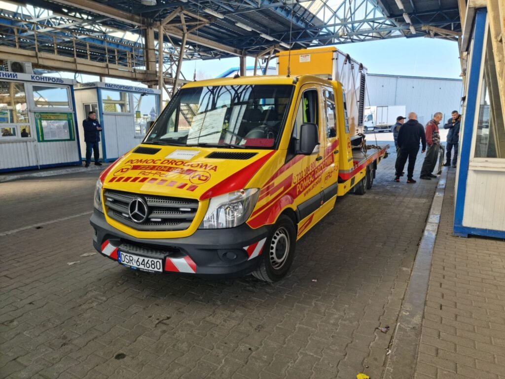 Laweta Legnica transportująca uszkodzony samochód po awarii na drodze w okolicach Legnicy