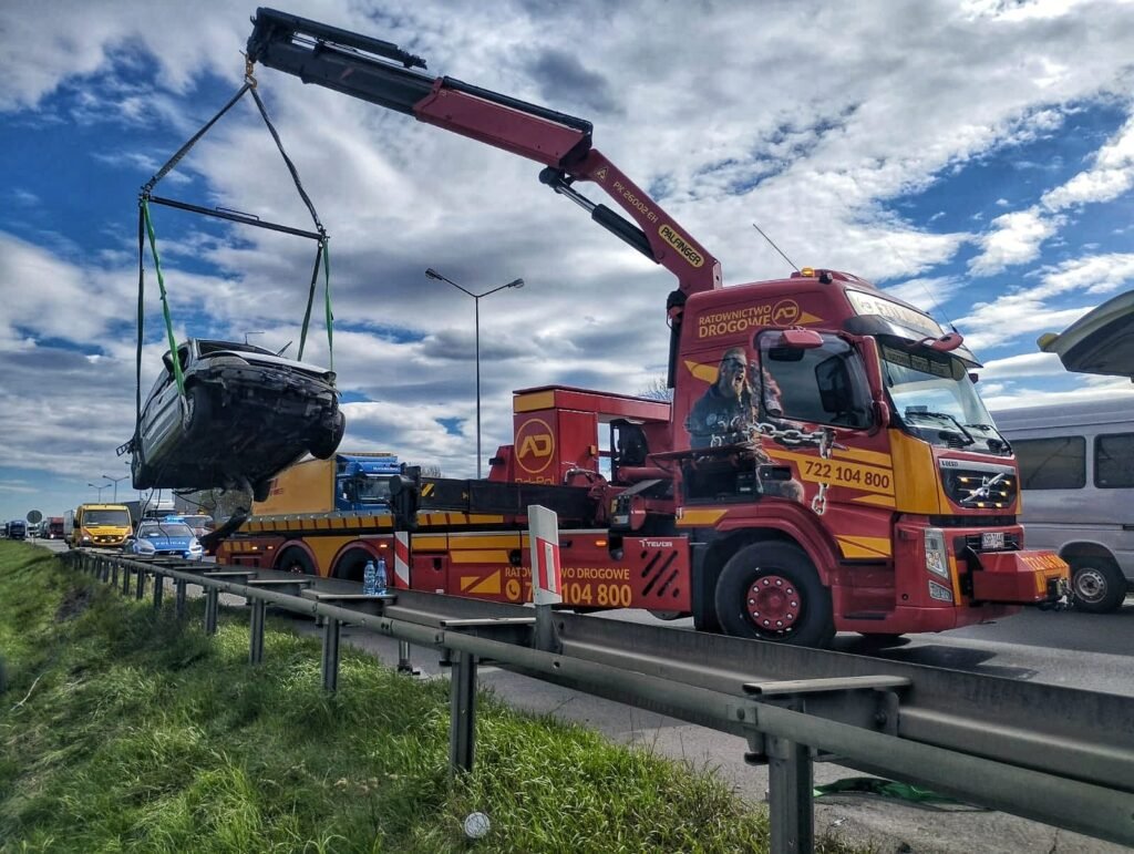 Nowoczesna laweta wykonująca holowanie Legnica samochodu osobowego na drodze w trudnych warunkach pogodowych
